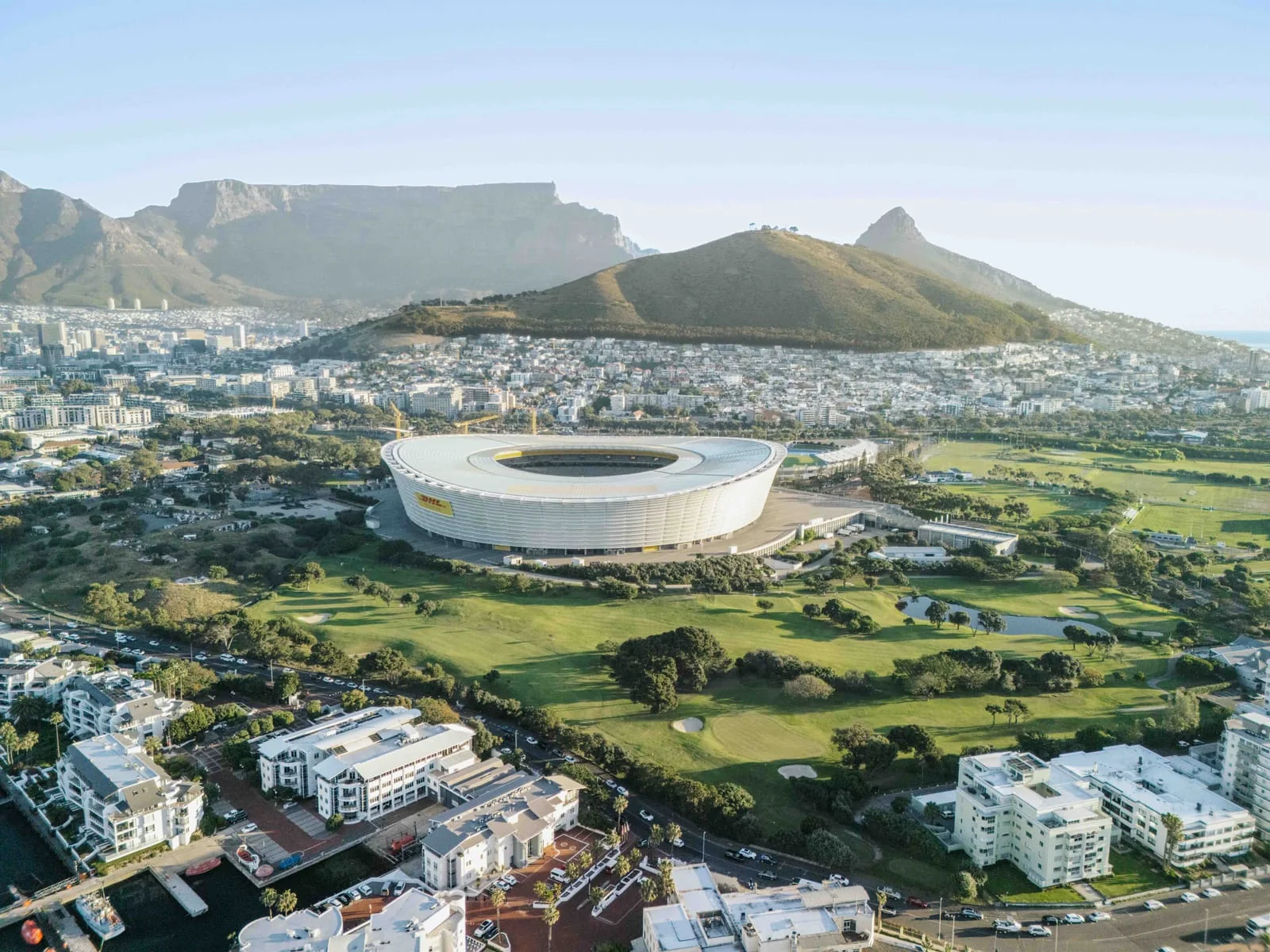 The stadium and the course in late light, with Table Mountain and Signal Hill